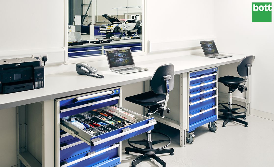 Workplace storage solution with blue drawers and grey laminate worktop in office area.
