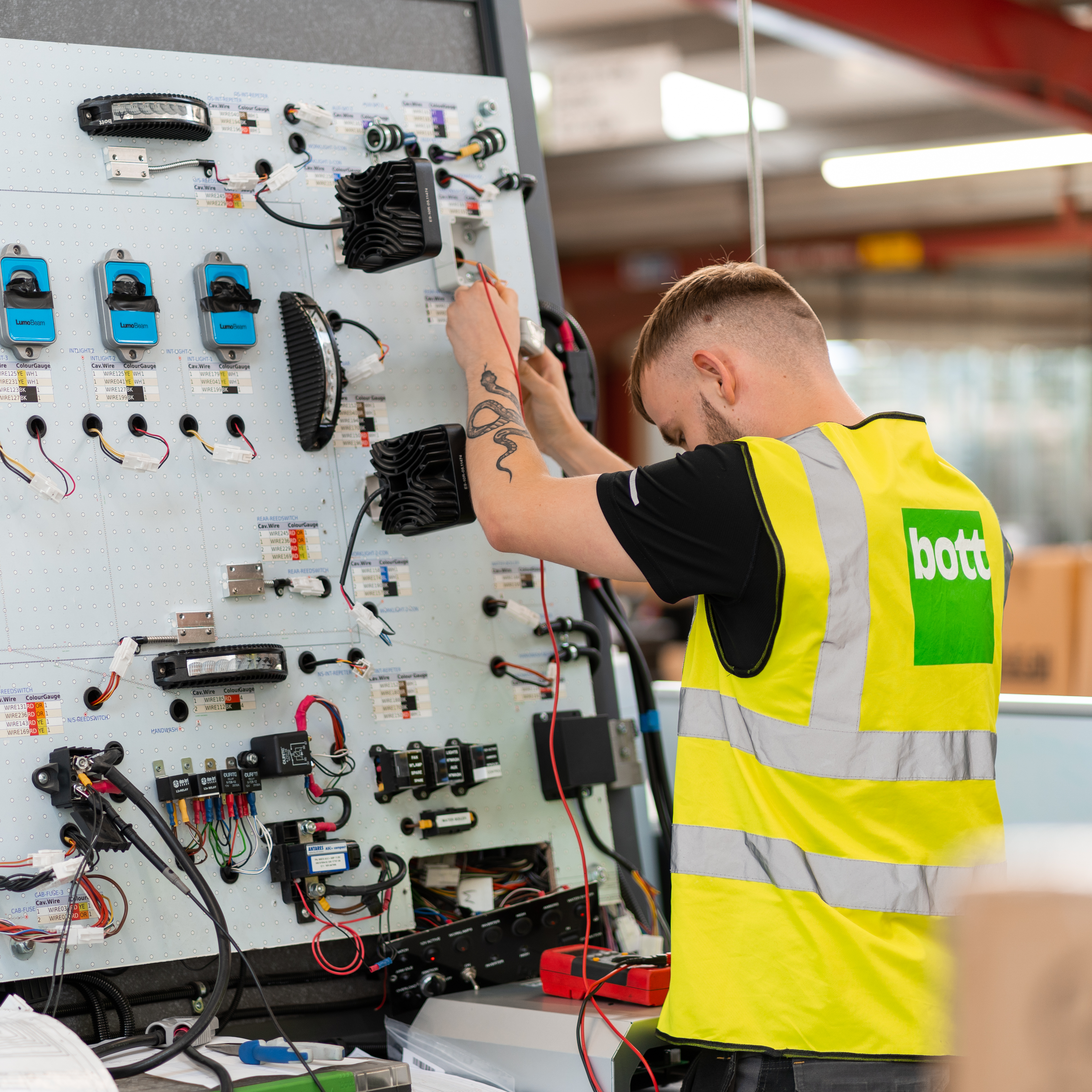 engineer working on electrical van conversion parts at vertical workstation - van racking & electric conversion specialists
