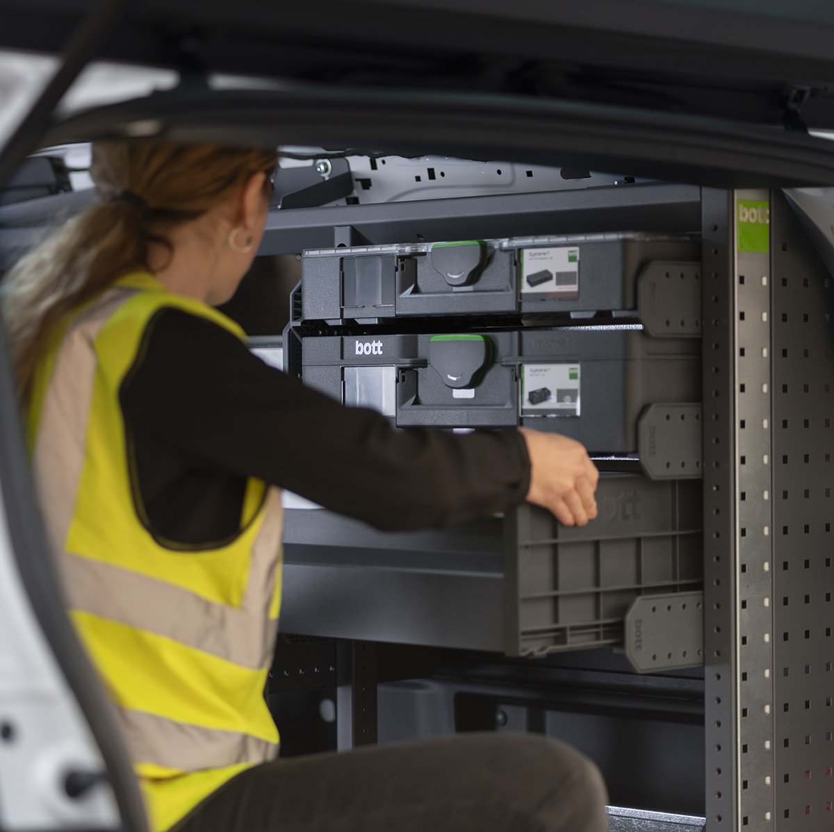 tradesperson in van with storage cases